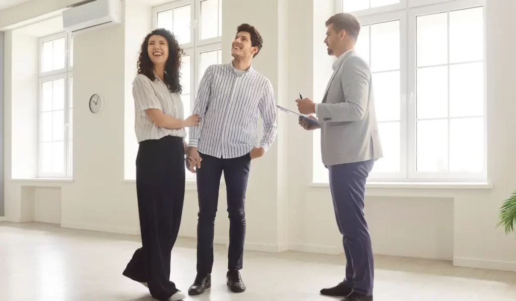 Tenant communication in action as a property manager speaks with smiling tenants during rental walkthrough.